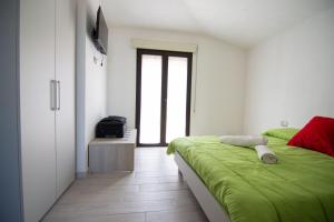 拉努塞伊La Finestra Sul Mare的一间卧室配有绿色的床和电视