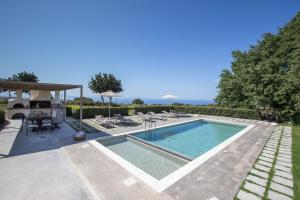Mikro MetochiLux Villa Mia with Heated Pool, 2km to Beach & Childrens Area!的别墅内的游泳池配有桌椅