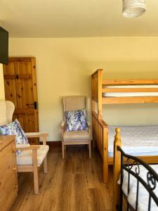 基拉尼Douglasha House V93RX64的一间卧室配有两张双层床和椅子