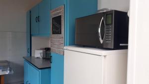 拉罗谢尔Maison de vacances familiale的厨房里冰箱上面的微波炉