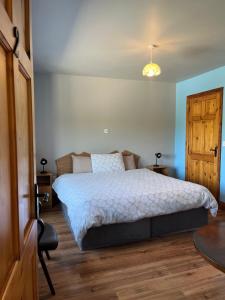 基拉尼Douglasha House V93RX64的一间卧室设有一张大床,铺有木地板