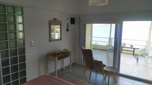 Aghios Petros AlonissosOdyssia near the Seaside的配有桌椅和镜子的客房