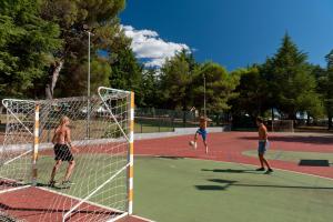 弗尔萨尔Koversada Apartments Naturist Park的一群男子在网球场上踢足球