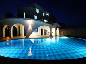 贝莱克Spectacular Villa with Private Pool in Antalya的一座游泳池,在晚上在建筑物前