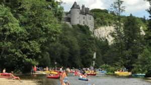 乌伊埃Gîtes Douillets : Chalet sur Pilotis的一群人乘着船在河上,有城堡
