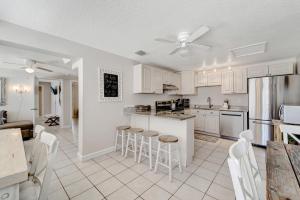 霍姆斯海滩Ocean View Suite的厨房配有白色橱柜和酒吧凳子