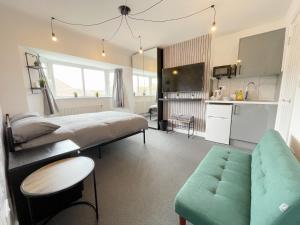 伦敦Cosy Bright Studio Apartment Close to Wembley Stadium的一间卧室配有一张床和一张沙发,还设有一间厨房