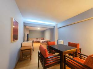 桑坦德Hotel Faranda Express Alisas Santander的一间带桌椅的客厅和一间卧室