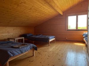 DurbeVītolu nams - atpūta ar saunu un makšķerēšanu的小木屋内带两张床的房间