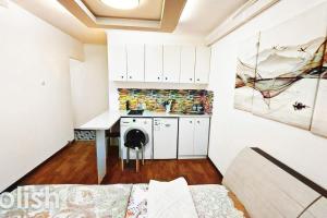 阿拉木图Двухместные апартаменты со всеми удобствами的小厨房配有白色橱柜和桌子