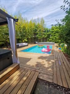 卢瓦尔河畔新堡Villa Moya, dependance privée Piscine & Spa的一个带木甲板和游泳池的后院游泳池