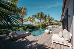 威廉斯塔德康提基海滩度假酒店的一个带游泳池、椅子和棕榈树的庭院