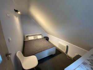 LipnicaLeśne Zacisze domki letniskowe的小房间设有一张床和一张白色椅子