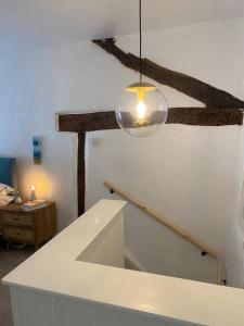 Upholland1750's cottage with open fire and beams的一间设有楼梯的房间,天花板上挂着一盏灯