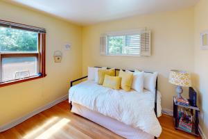 西雅图Wallingford Heights的一间卧室设有一张黄色墙壁和窗户的床