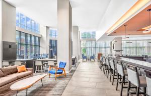 休斯顿Hyatt Place Houston Medical Center的一个带沙发和椅子的大堂和一间酒吧