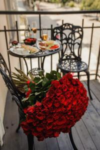 敖德萨德利巴斯酒店的一张桌子上一束红玫瑰,两把椅子