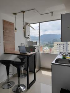 马尼萨莱斯Casa Colibrí Hospedaje Manizales a 2 min del Cable y 1 min Zona G的厨房配有带笔记本电脑的桌子