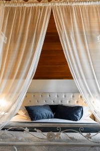 格拉玛多凯尔豪斯酒店的天蓬床,配有白色窗帘和蓝色枕头