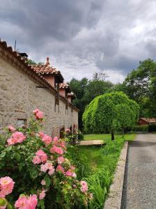 洛特河畔的维伦纽夫Gîte le domaine de Dolly的路边有粉红色花的建筑