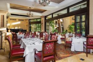 新巴利亚塔Villa La Estancia Beach Resort & Spa Riviera Nayarit的用餐室配有白色的桌子和红色的椅子