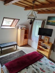 BadacsonyörsKlára Vendégház的一间卧室配有一张床和一台平面电视