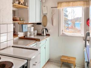 DalaröHoliday home DALARÖ II的一间小厨房,配有白色的橱柜和窗户