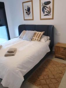 格兰阿利坎特Gran Apartment-Iconic Sea View的卧室内的一张带白色床单和枕头的床
