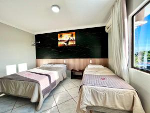 伊瓜苏芬尼斯酒店 的客房设有两张床和一台墙上的电视。