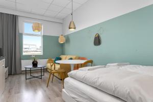 雷克雅未克Icelandic Apartments by Heimaleiga的卧室配有一张床和一张桌子及椅子