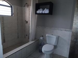 危地马拉L´Aurora Inn hostal的浴室配有卫生间、淋浴和浴缸。