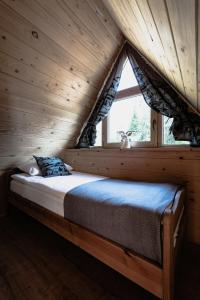 考斯赛力克Obrochtowa Chata的木制客房的一张床位,设有窗户