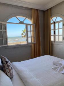 杰迪代AMWAJ HOTEL的一间卧室配有一张床,享有海滩美景
