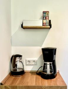 雷姆沙伊德Sali - R1 - Apartmenthaus, WLAN, TV的咖啡壶旁边木架上的咖啡壶