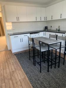 珀利Beautiful-2 bedroom Apartment, 1 bathroom, sleeps 6, in greater london (South Croydon). Provides accommodation with WiFi, 3 minutes Walk from Purley Oak Station and 10mins drive to East Croydon Station的厨房配有桌椅和白色橱柜。