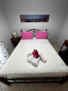 尼基亚娜Anna's Apartments的一张带粉色和白色毛巾及粉色枕头的床