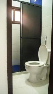 伊塔乌纳斯Pousada Estalagem Vila Tania的浴室设有白色卫生间和黑色门。