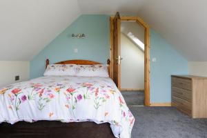 伦维尔Honeysuckle Cottage的一间卧室配有一张带花卉床罩的床