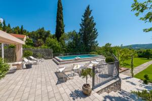 米利尼Luxury Vila Divina-Exceptional privacy的一个带游泳池和躺椅的庭院