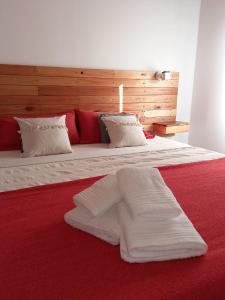 埃斯克尔Casa Nera的一张红色的大床,配有白色床单和枕头