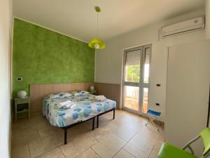 托雷奥沃Lu Jentu的一间卧室设有一张床和绿色的墙壁