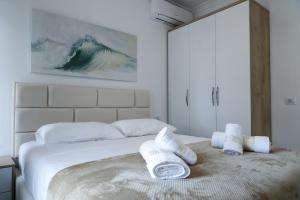 维利波吉Fishta Quality Apartments Q5 36的白色卧室,配有带毛巾的床