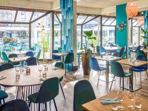马赛Novotel Marseille Est Porte d'Aubagne的餐厅设有桌椅和窗户。