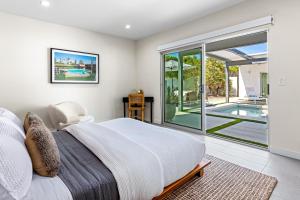 棕榈泉Desert Orchid Retreat的一间卧室设有一张床和一个游泳池