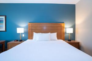 斯阔米什桑德曼斯阔米士酒店的一间卧室配有一张带两盏灯的大型白色床。