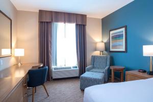 斯阔米什桑德曼斯阔米士酒店的酒店客房配有一张床、一张桌子和一把椅子。