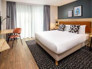 萨顿Aparthotel Adagio London Sutton Point的酒店客房设有一张大床和一张书桌。