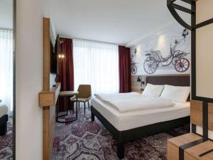 科堡ibis Styles Coburg的一间卧室配有一张床,另一间卧室墙上配有自行车