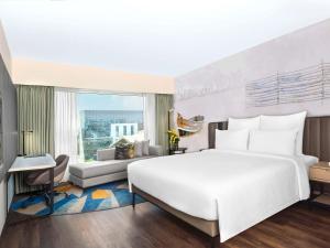 孟买Novotel Mumbai International Airport的一间带白色大床的卧室和一间客厅
