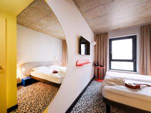 明斯特ibis budget Münster City的酒店客房设有两张床和窗户。